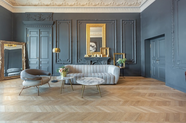 Interni chic della stanza in stile rinascimentale del XIX secolo con mobili di lusso moderni. le pareti di nobile colore scuro sono decorate con stucchi e cornici dorate, parquet in legno.