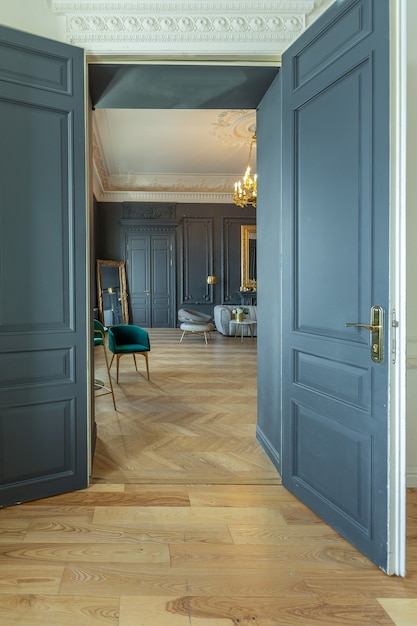 Interni chic della stanza in stile rinascimentale del XIX secolo con mobili di lusso moderni. le pareti di nobile colore scuro sono decorate con stucchi e cornici dorate, parquet in legno.