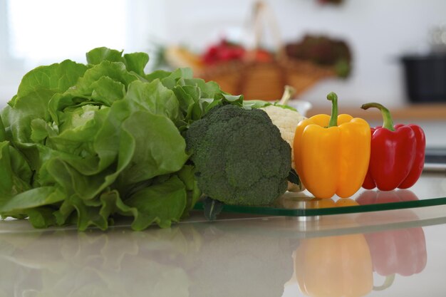 Interni della cucina Molte verdure e altri pasti al tavolo di vetro sono pronti per essere cucinati presto