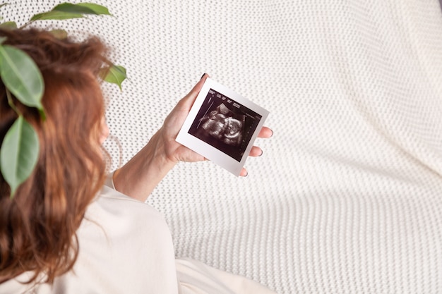 Interni di immagine di ultrasuono della tenuta della donna incinta a casa