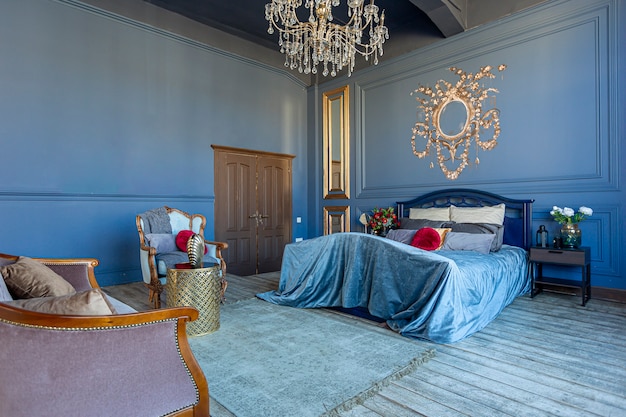 Interni di lusso ed eleganti camere da letto in colore blu intenso con mobili antichi costosi ed elementi dorati in stile barocco