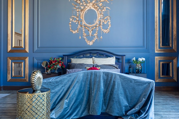 Interni di lusso ed eleganti camere da letto in colore blu intenso con mobili antichi costosi ed elementi dorati in stile barocco