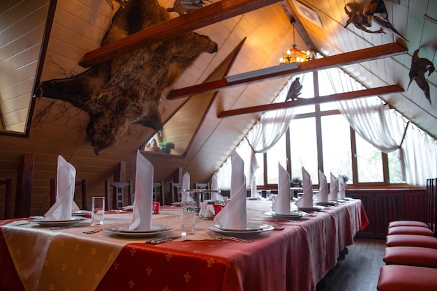Interni di ristoranti rustici con tema di caccia e tavolo lungo per banchetti