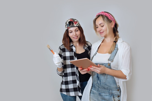 Interni domestici, due ragazze carine, designer e imbianchini, riparano in casa un team di decoratori