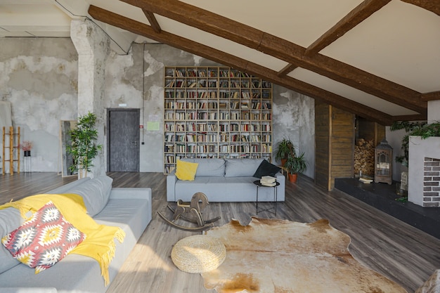 Interni in stile loft scuro di grande casa di campagna accogliente. appartamento open space con angolo cottura, zona riposo e zona letto. Enormi finestre e decorazioni in legno