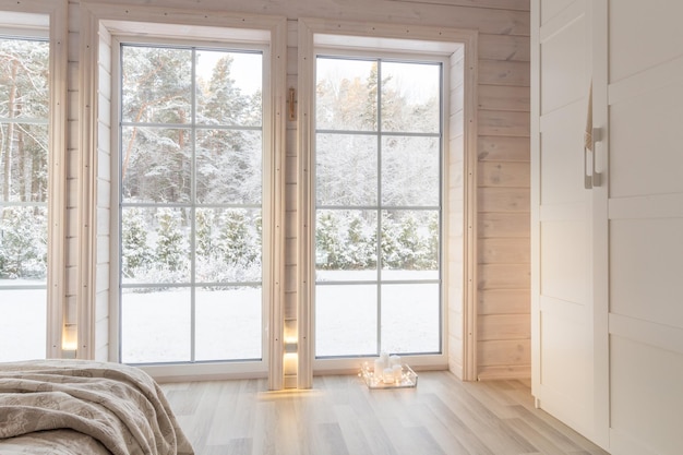 Interni luminosi, stanza in casa in legno con ampia finestra che si affaccia sul cortile d'inverno. Stile scandinavo