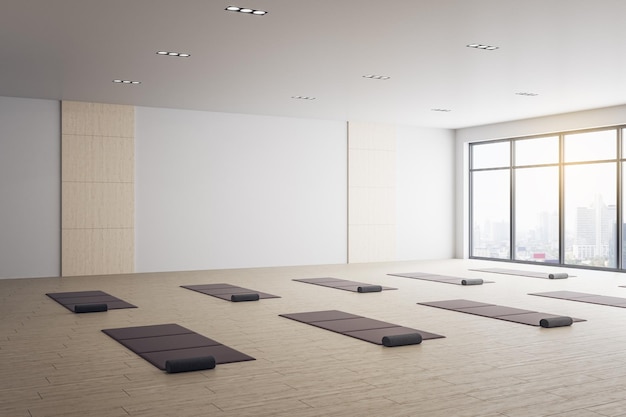Interni minimalisti dell'aula di yoga con stuoie e vista sulla città