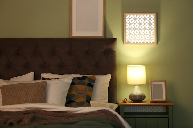 Interni moderni con letto comodo e lampada elegante