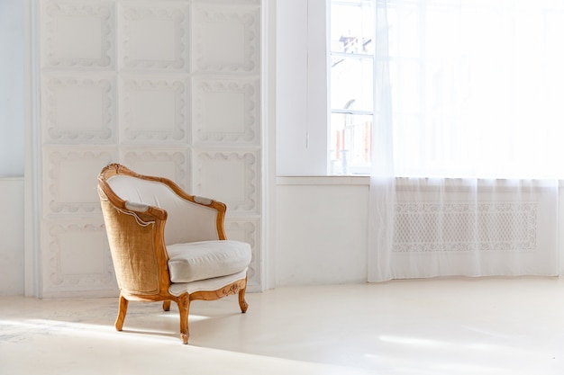 Interno alla moda della camera da letto del sottotetto. Ampio appartamento di design con pareti chiare, ampie finestre e poltrona. Decorazione moderna e pulita con mobili eleganti in stile scandinavo minimalista.