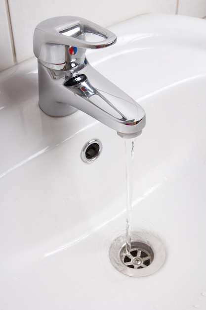 Interno del bagno con lavabo bianco e rubinetto d'argento