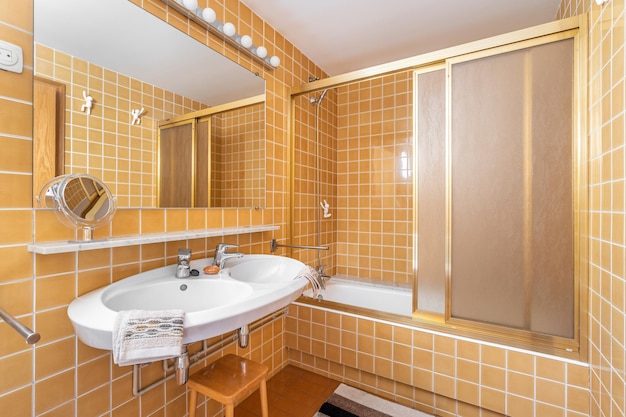 Interno del bagno giallo brillante con doccia, vasca e lavandino