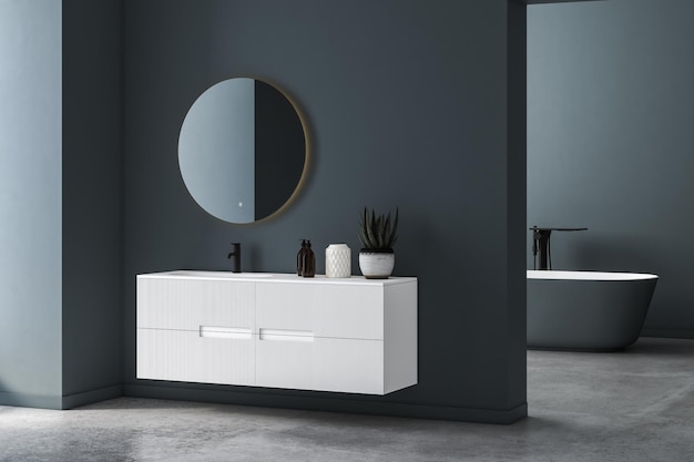 Interno del bagno moderno e minimalista, mobiletto del bagno moderno, lavabo bianco, specchio ovale, cemento.