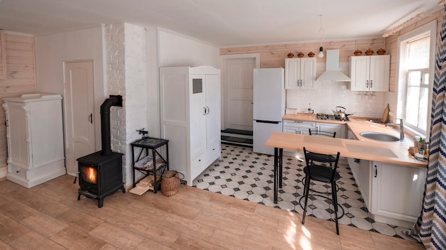 Interno del monolocale con camino in stile scandinavo in un'accogliente casa privata, dove il soggiorno è combinato con la cucina.