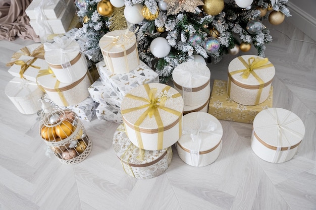 Interno del soggiorno con un albero di Natale e decorazioni Bellissimo albero di Natale con decorazioni festose in oro bianco Concetto di Natale e Capodanno presenti scatole e regali