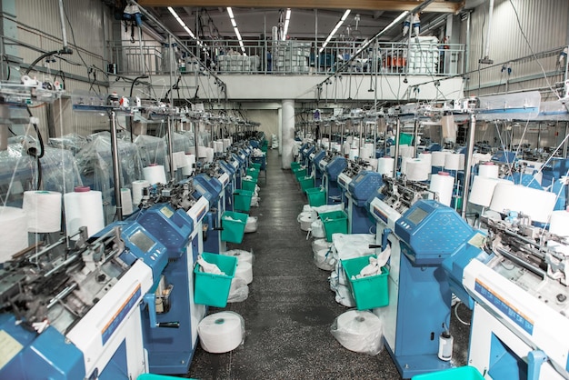 Interno dell'officina tessile del negozio della fabbrica dell'indumento con il concetto di industria delle macchine da cucire