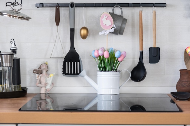 Interno della cucina e dettagli del decoro degli utensili con decorazione pasquale di uova colorate in stile loft Interno festivo di una casa di campagna