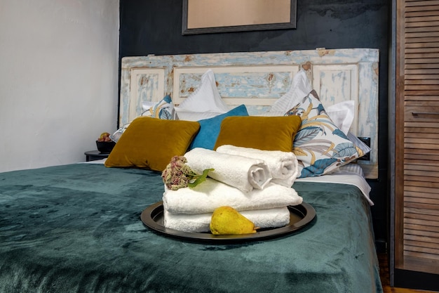 Interno della moderna camera da letto di lusso con cuscini sul letto in monolocali in stile chiaro