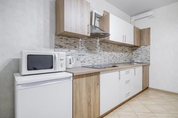 Interno della moderna cucina di lusso in monolocali in stile minimalista con colore bianco chiaro