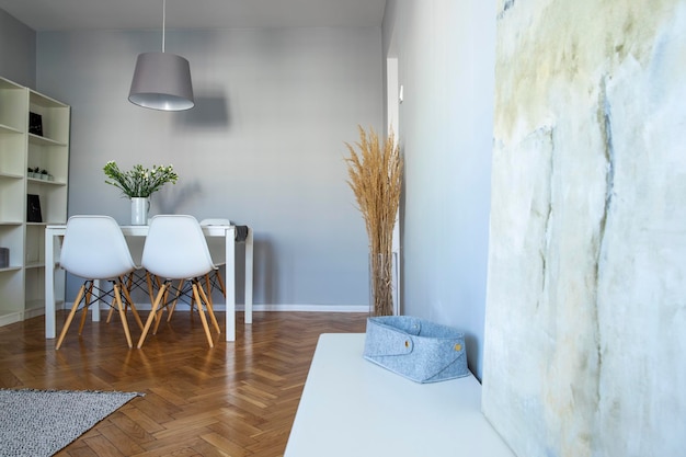 Interno della sala da pranzo con sedie bianche a tavolo di legno in una sala da pranzare alla moda