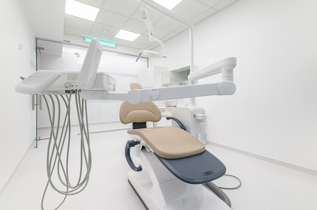 Interno della sala medica di chirurgia dentale bianca, primo piano di attrezzature speciali, copia dello spazio a destra