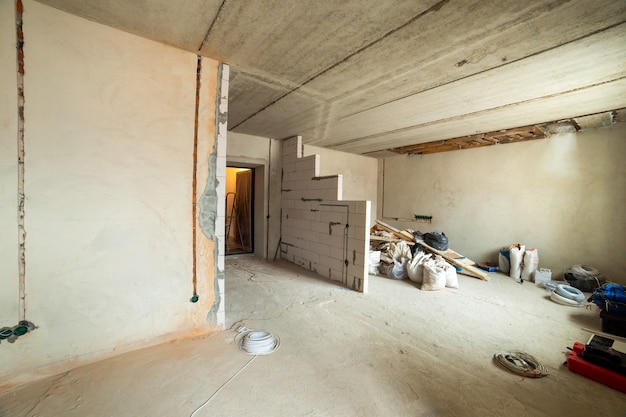 Interno di un appartamento con pareti nude e soffitto in costruzione.