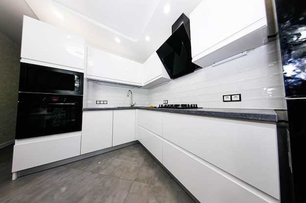 interno di una cucina bianca di dimensioni compatte con elettrodomestici moderni incorporati