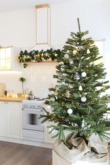 Interno di una cucina luminosa natalizia decorata con un albero di Natale e ghirlande