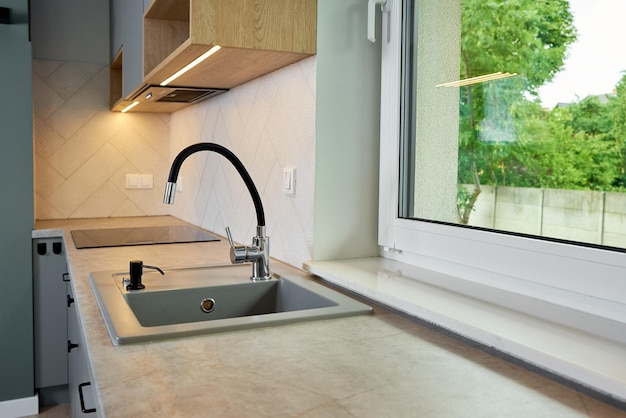 Interno di una cucina moderna con lavello vicino alla finestra