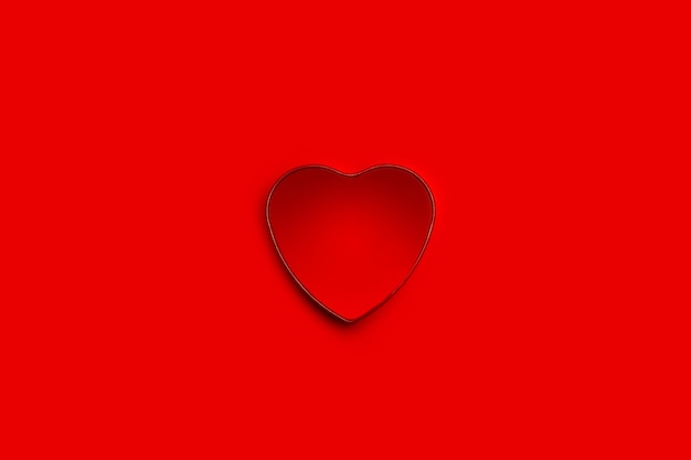 Interno di una scatola aperta a forma di cuore su uno sfondo rosso con spazio per la copia in una vista dall'alto