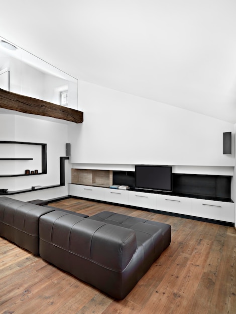 Interno soggiorno moderno in primo piano il divano in pelle marrone il pavimento è in legno
