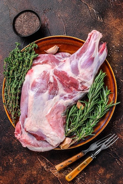 Intero fresco Carne di spalla di agnello crudo su un piatto