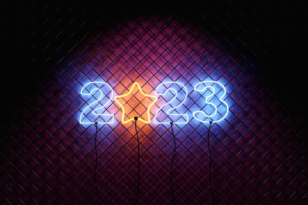 Intestazione del calendario neon numero 2023 sullo sfondo della parete a rete Felice anno nuovo al neon 2023