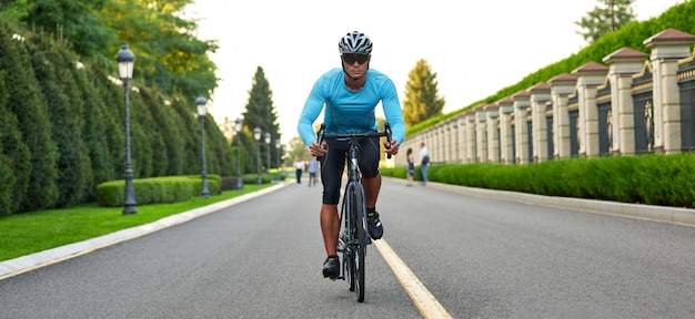 Intestazione del sito web dell'inquadratura ritagliata di un uomo in sella a una mountain bike nel parco durante il tramonto