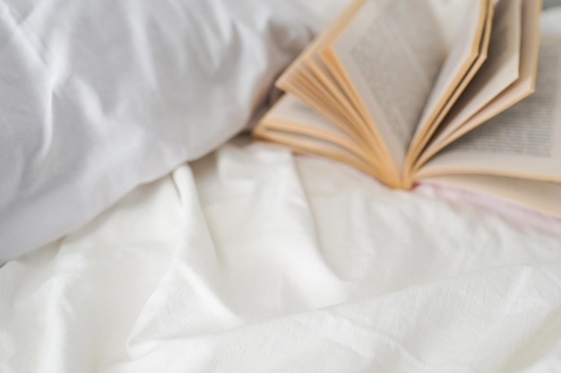 Intimità, comfort, concetto di vacanze - accogliente camera da letto con letto e libro, copia spazio per il tuo testo