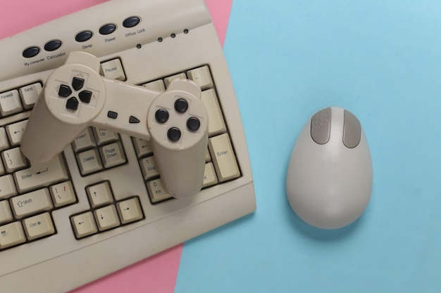 Intrattenimento retrò. Mouse per PC vecchio stile, tastiera, gamepad su rosa blu