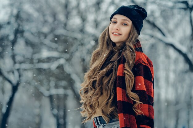 Inverno giovane donna ritratto bellezza gioiosa ragazza modello che ride e si diverte nel parco invernale