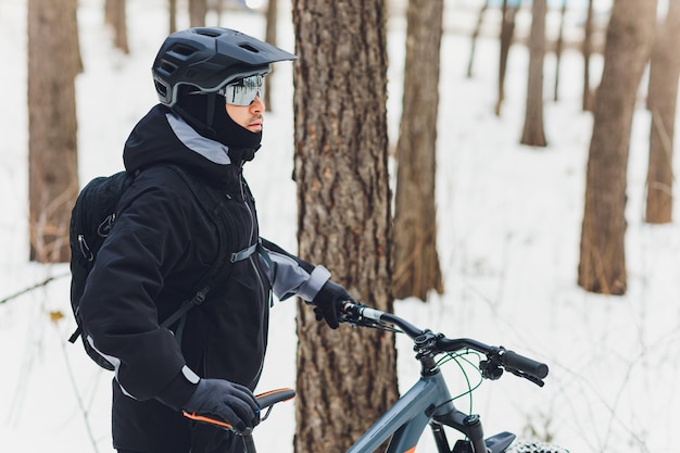 Inverno in sella a una mountain bike nella foresta.