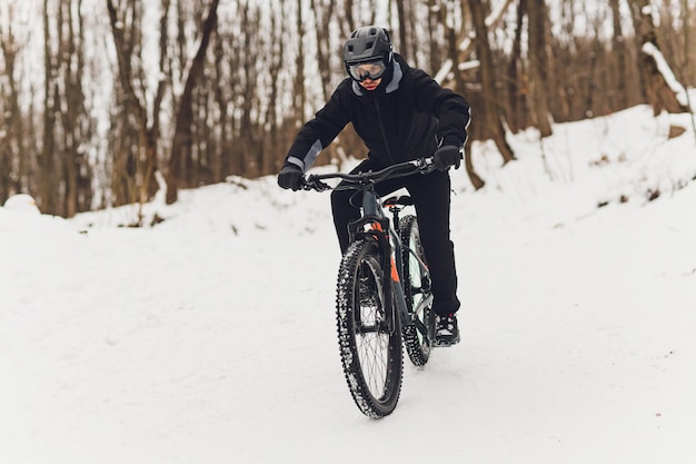 Inverno in sella a una mountain bike nella foresta.