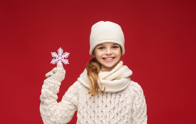 inverno, persone, concetto di felicità - ragazza con cappello, sciarpa e guanti con un grande fiocco di neve