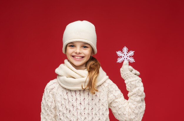 inverno, persone, concetto di felicità - ragazza con cappello, sciarpa e guanti con un grande fiocco di neve