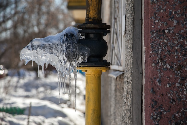 Inverno russo del tubo del gas congelato nella neve bianca della piccola città sulle strade