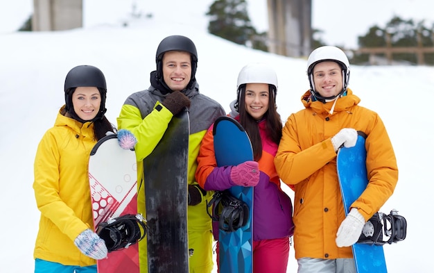 inverno, tempo libero, sport estremo, amicizia e concetto di persone - amici felici in caschi con snowboard