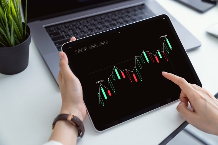 Investimento in borsa, tavoletta digitale a mano e grafico commerciale sul posto di lavoro, valutando il valore di mercato.