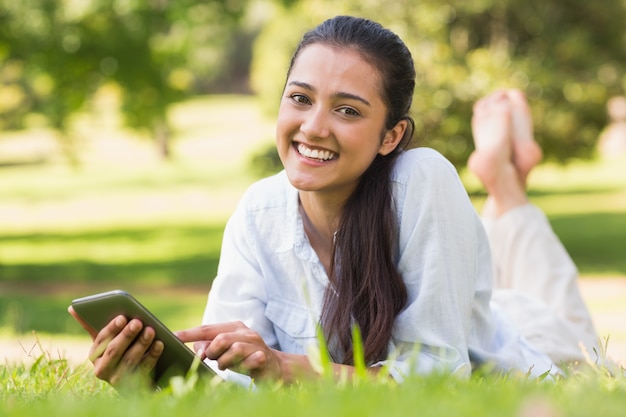 Invio di messaggi di testo della donna mentre rilassandosi nel parco