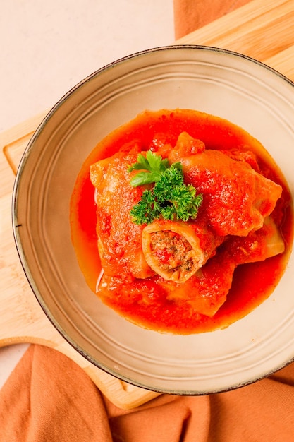 Involtini di cavolo ripieni con carne macinata in salsa di pomodoro su sfondo beige vista dall'alto nessun fuoco selettivo delle persone