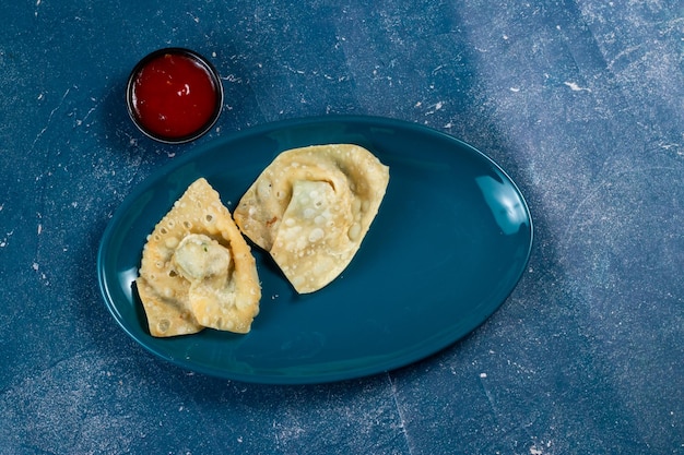 Involtini di dim sum wonthon fritti croccanti con salsa di pomodoro serviti in un piatto isolaed sulla vista del tavolo