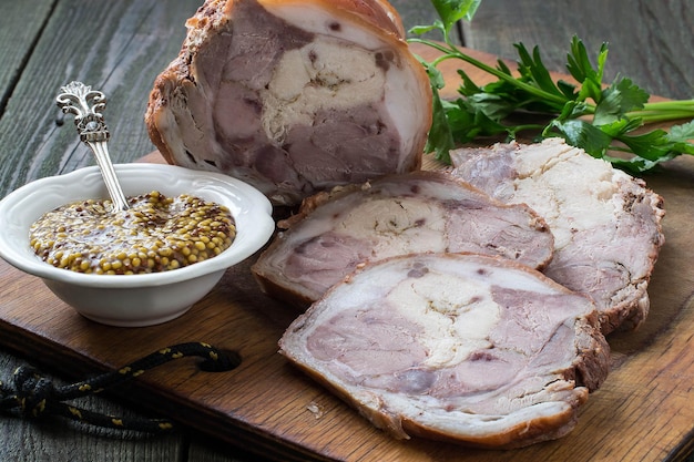 Involtini di maiale e pollo fatti in casa con senape e prezzemolo per la preparazione di snack freddi su una vecchia tavola di legno in stile rustico