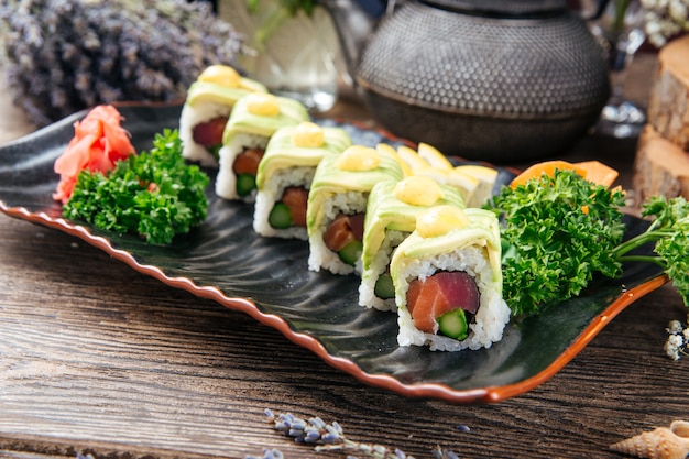 Involtini di sushi appetitosi con fette di tonno e avocado