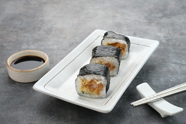 Involtini di sushi con nori serviti su un piatto bianco.