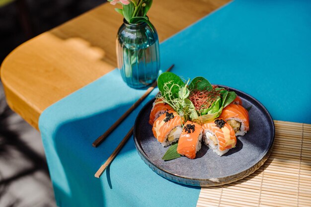 Involtini di sushi freschi e gustosi con salmone sul tavolo servito al ristorante con un bellissimo lampo